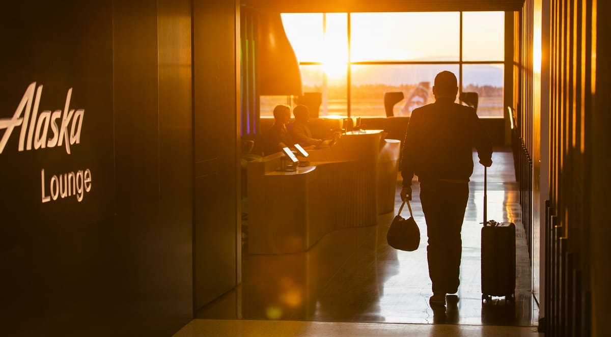 Entrance to Alaska Airlines lounge with sun in background.