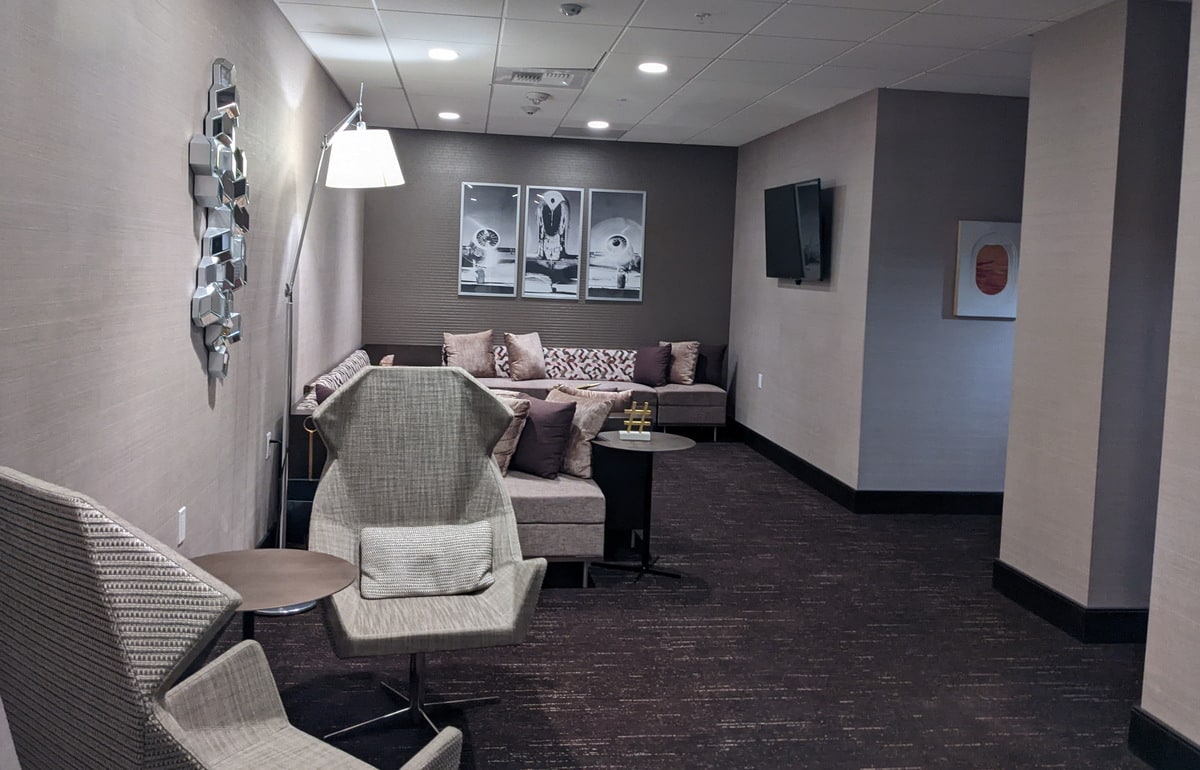 View inside the main seating area of the Transfer Lounge with seating, tables, and aviation art on the walls.