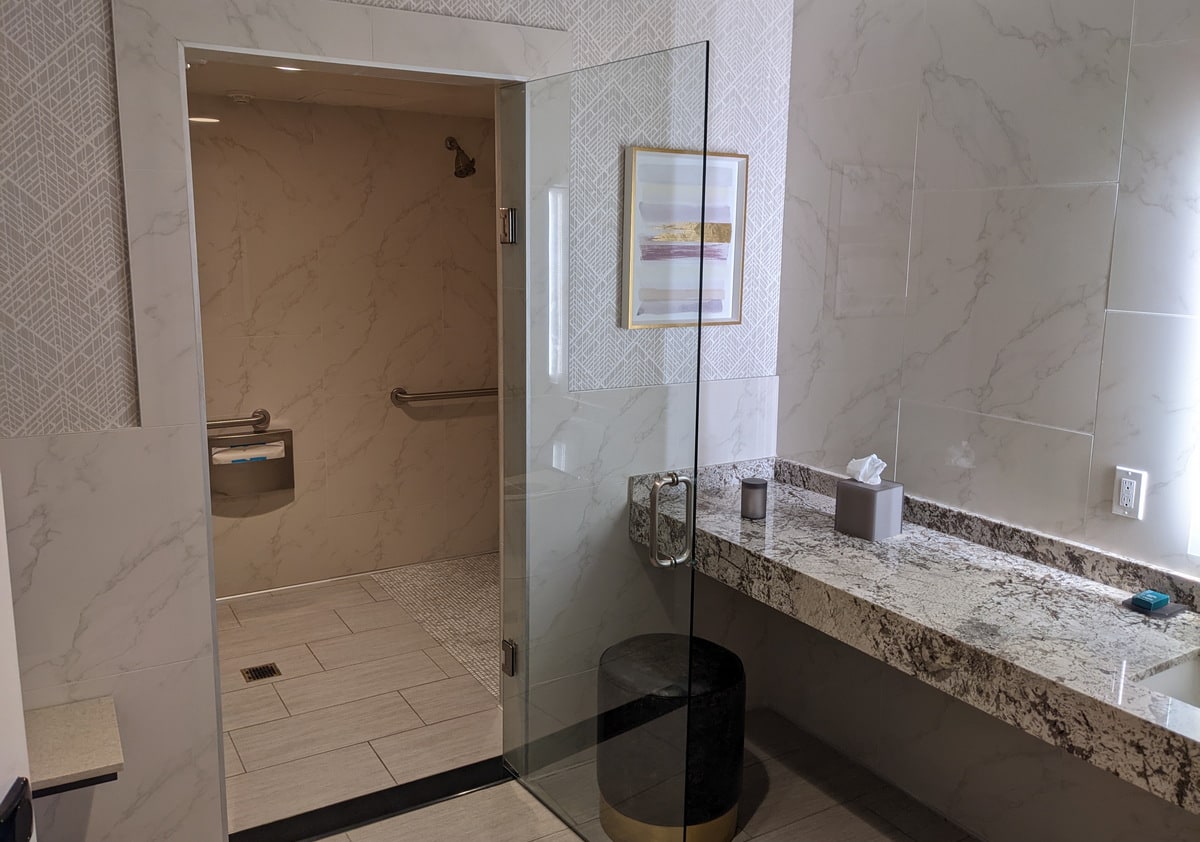 shower room with a walk-in accessible shower and full-size mirror.