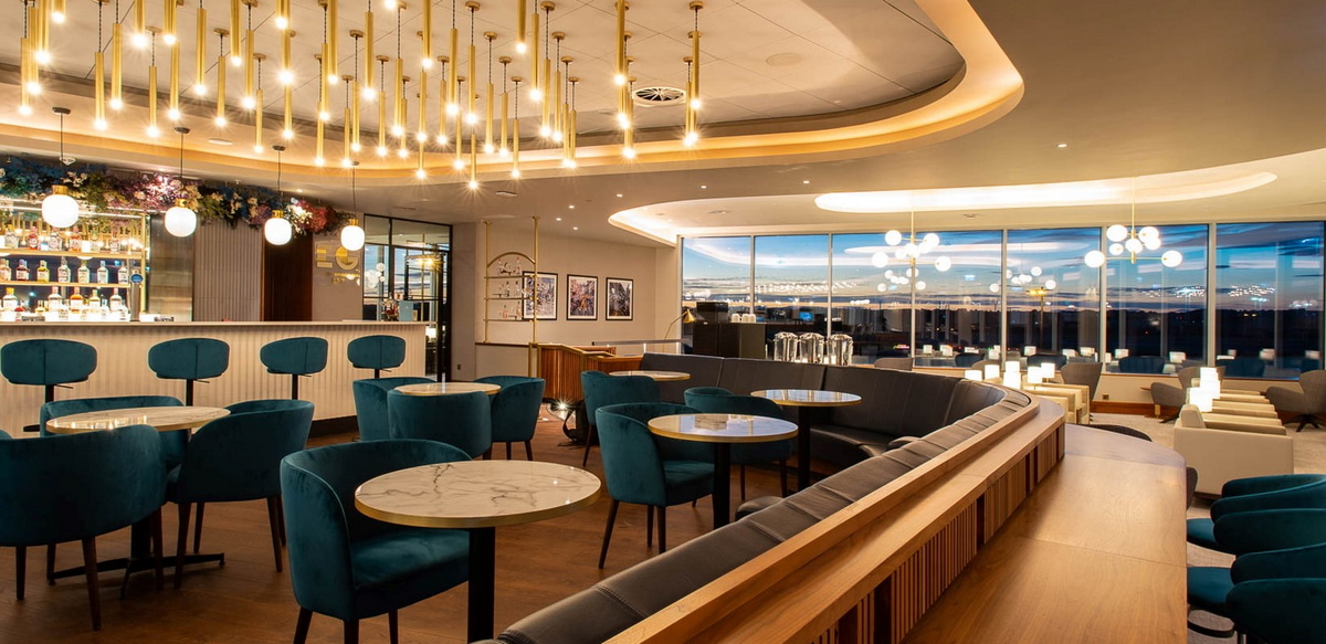 Bar and seating area near bar, with windows in the background.