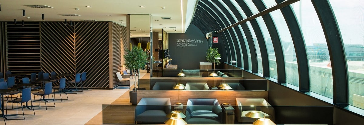 Seating area and windows inside of lounge with tables and chairs.