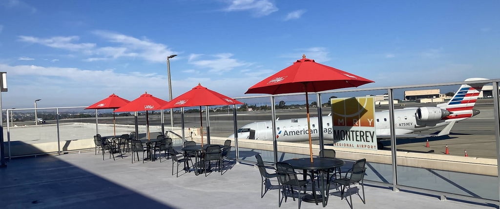 View of the observation deck at Wood Bar and Grill with tables and view of airport.
