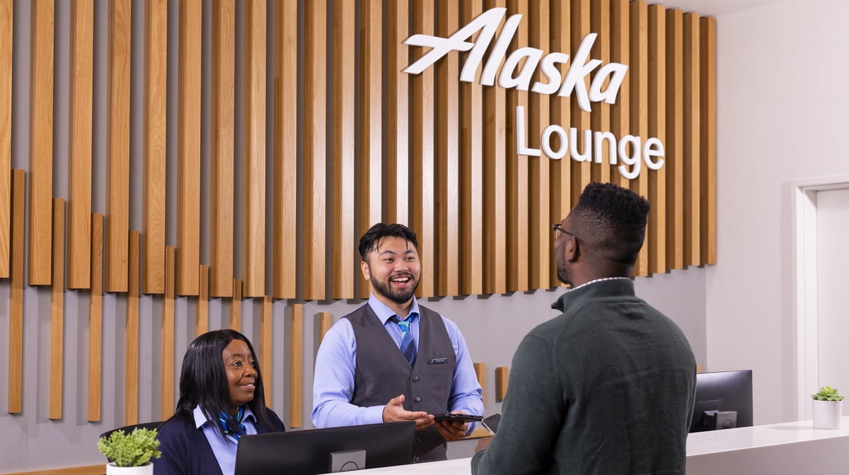 Lounge desk with employees and a customer.