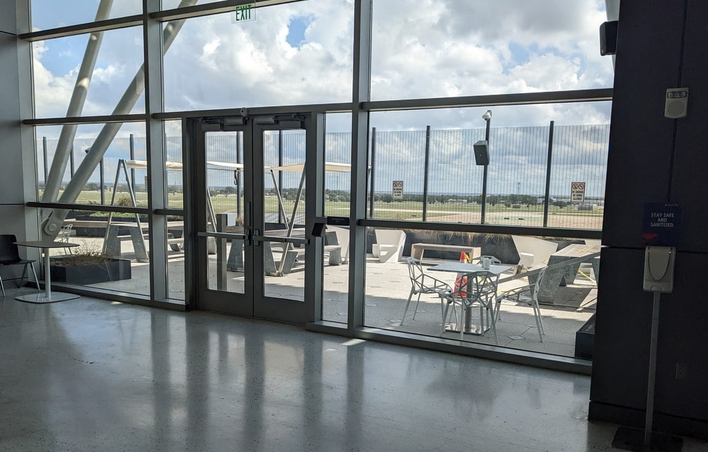 doors on inside of airport terminal, with view of the outdoor patio.