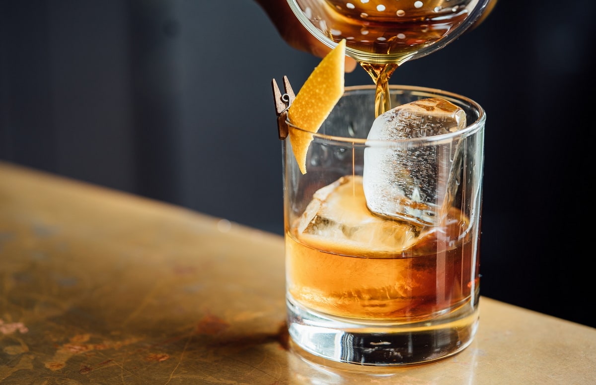 Bar drink being poured into glass.