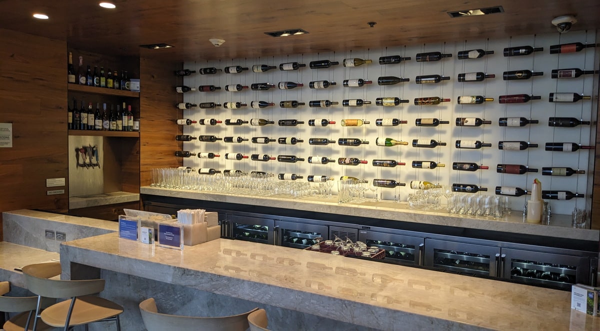 bar area with seating, bottles of wine in the back of the bar.