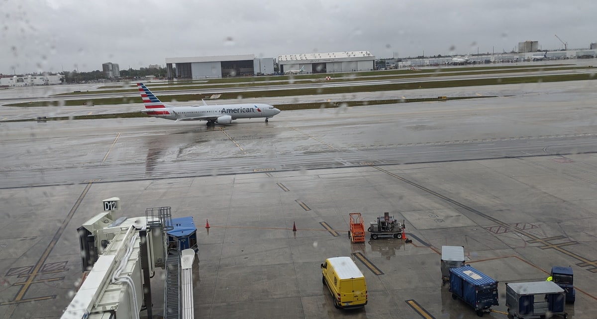 view outside at MIA airport, with an American Airlines plane and gate.