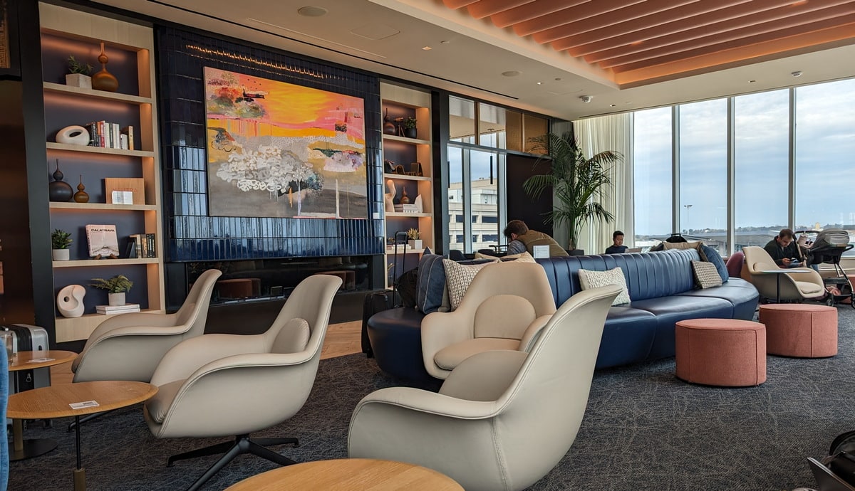 main seating area with sofas, chairs, tables, and large windows in the background.
