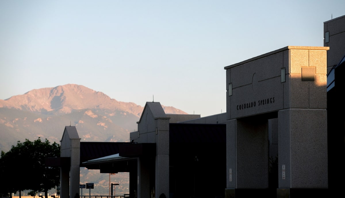 Front entrance to the COS airport with mountains in the background.