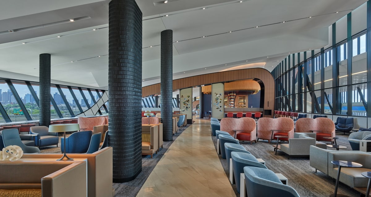 Lounge seating area with charis and windows showing the downtown skyline.