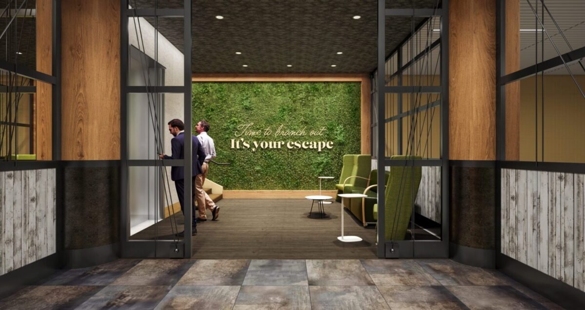 reception area with green wall and two people checking in.