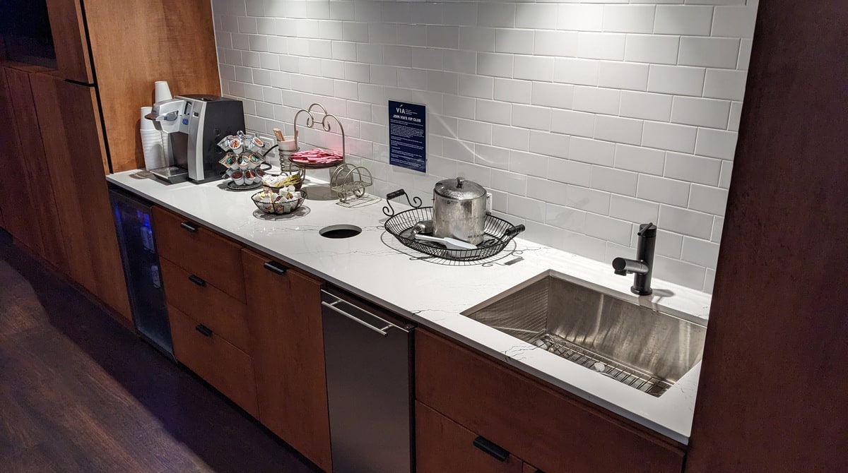 counter with fridge, coffee machine and sink.