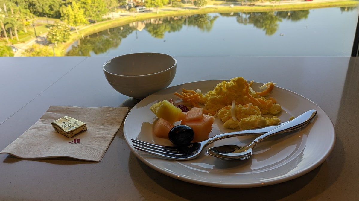 plated food with eggs and fruit, with a view of the lake in the background.