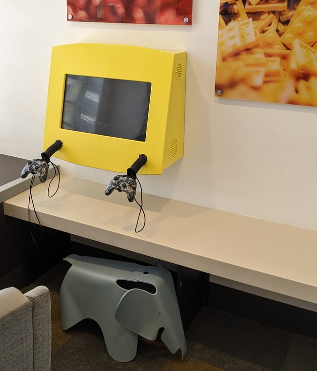 Tables and seating with a flight monitor in the background.