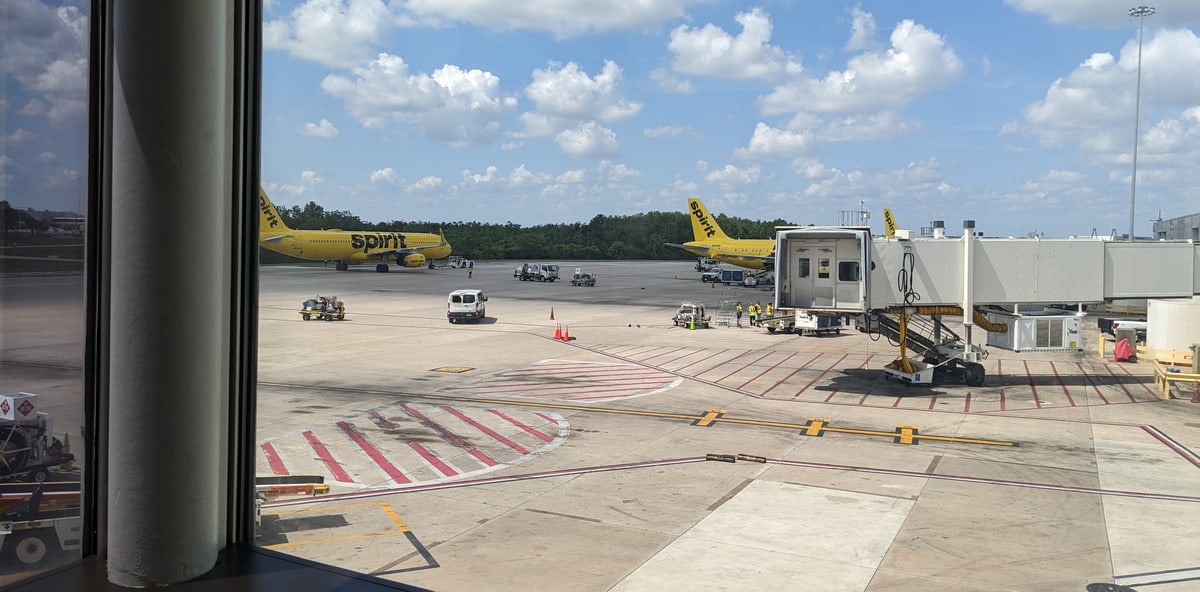 view of the outside from inside the lounge showing planes and gates.