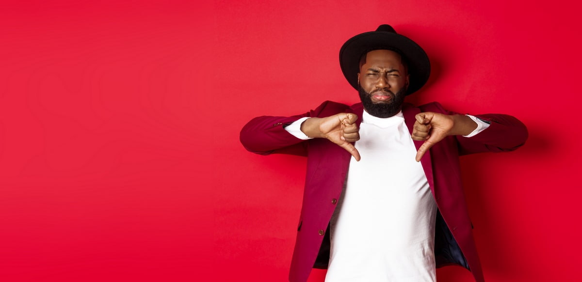 man with both thumbs pointing down with a red background.