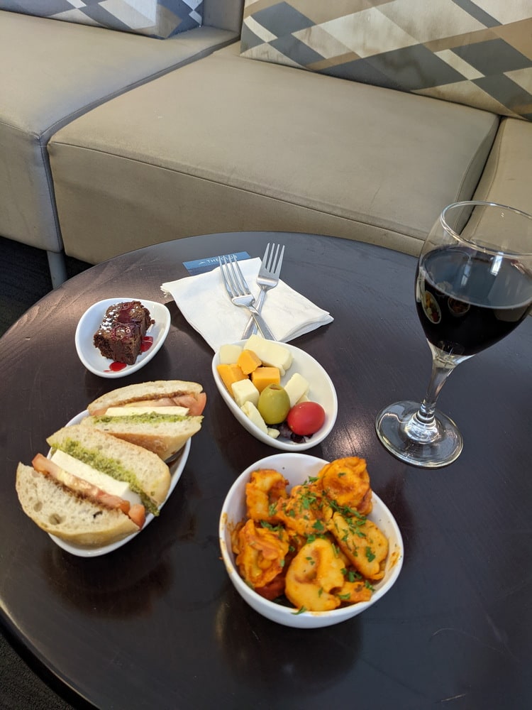 food on table including pasta salad and wine.