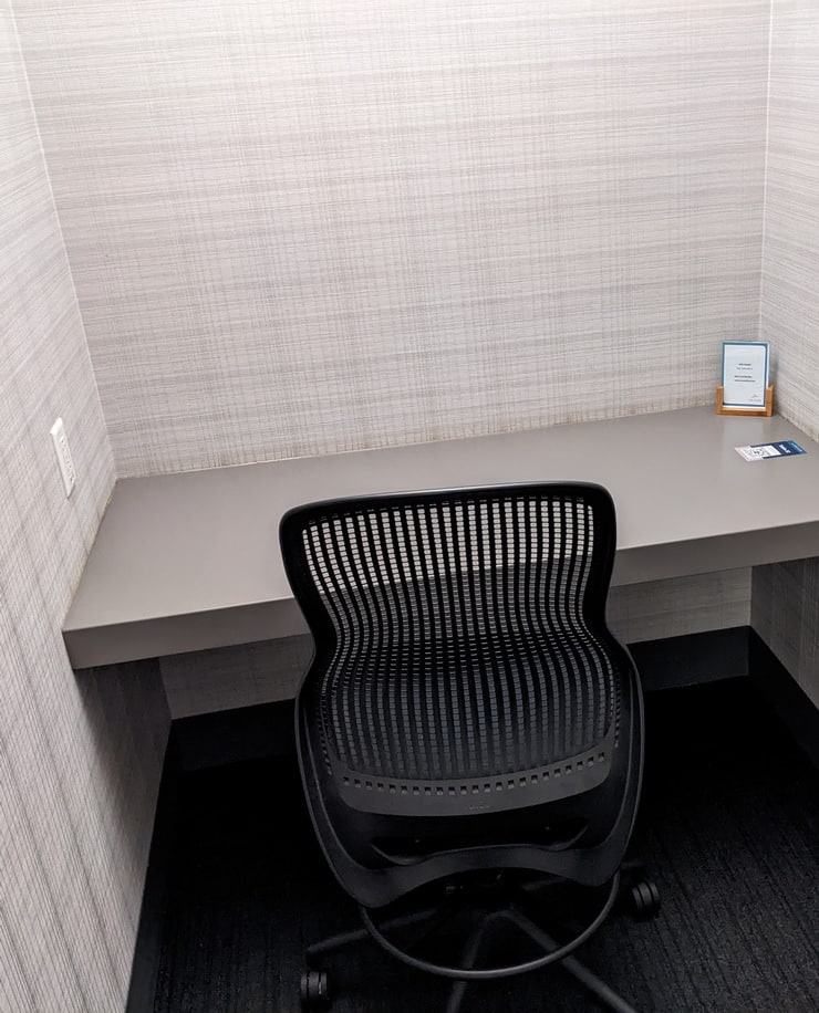 inside the private phone room with a desk and chair.