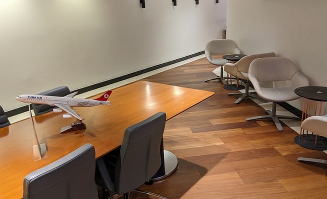 conference table with chairs, and a flight information monitor.