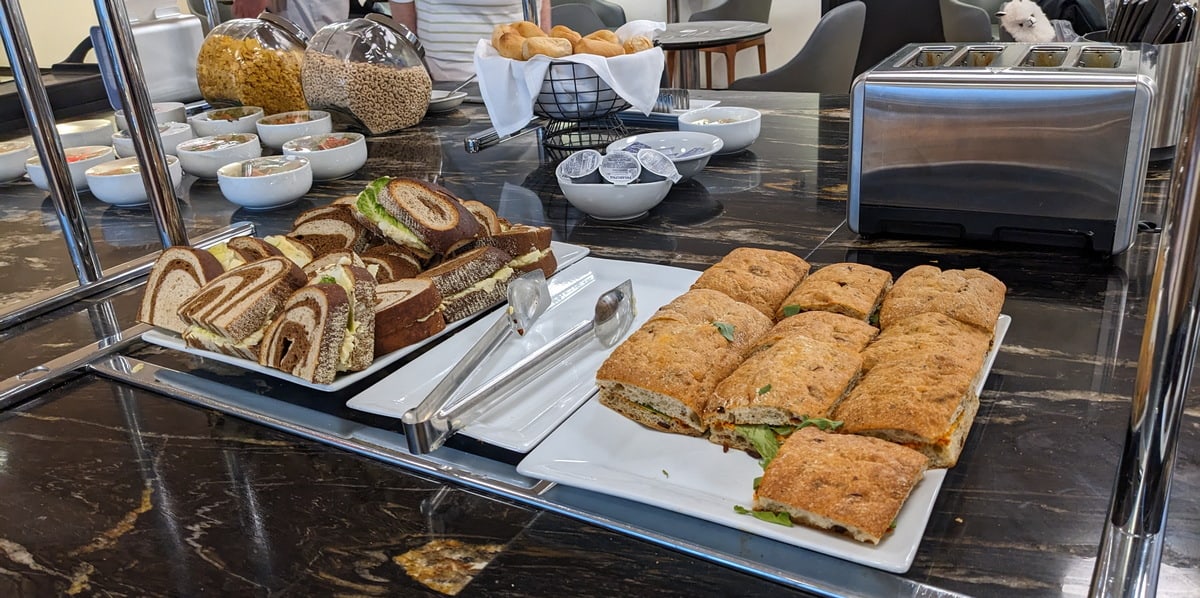 food buffet station with sandwiches and cereal.