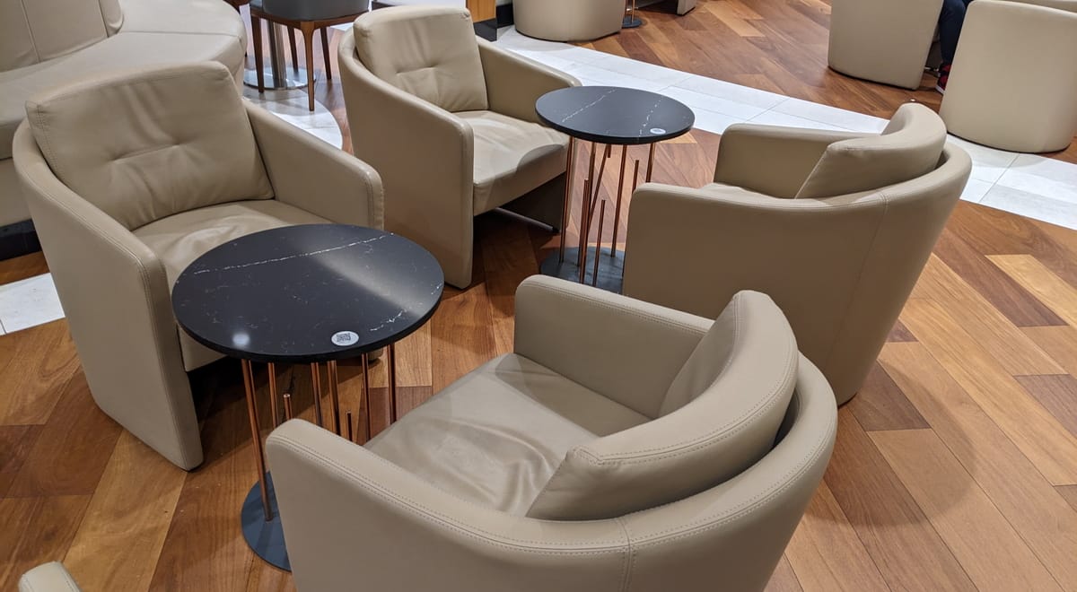 Comfortable lounge chair and table with a QR code for ordering.