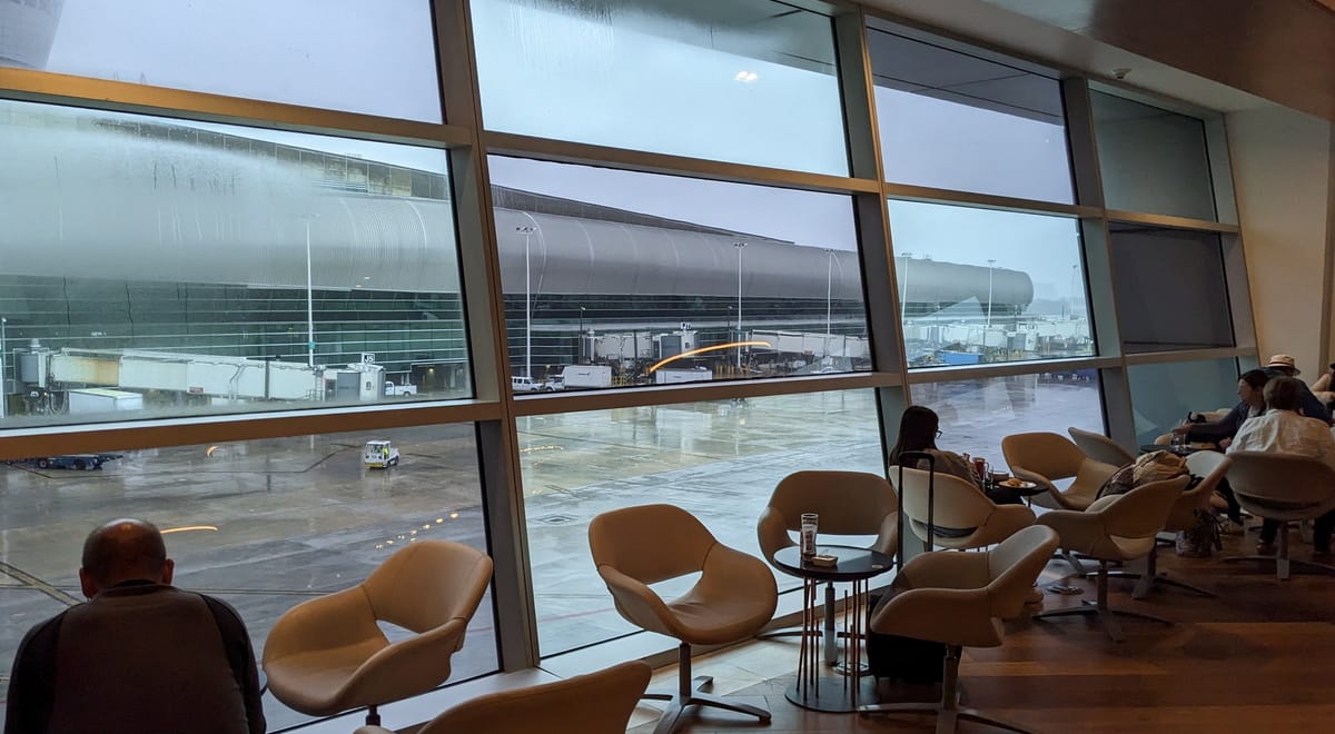 Floor-to-ceiling windows and chairs with outside view.