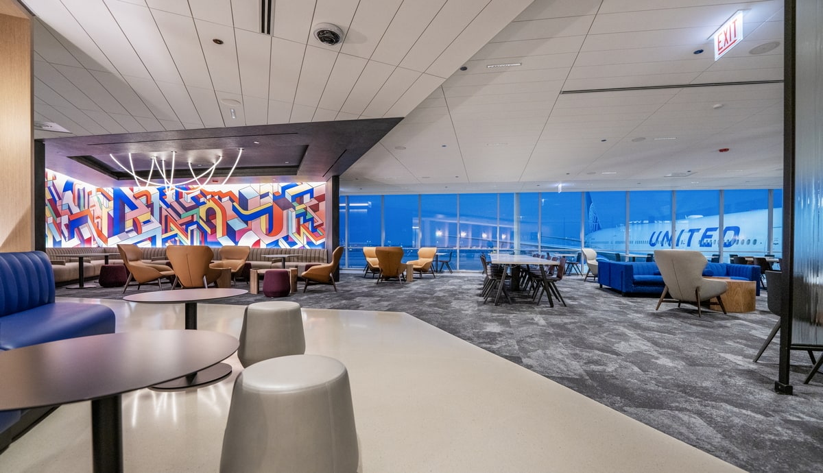 rendering of the seating area with large windows in the background.