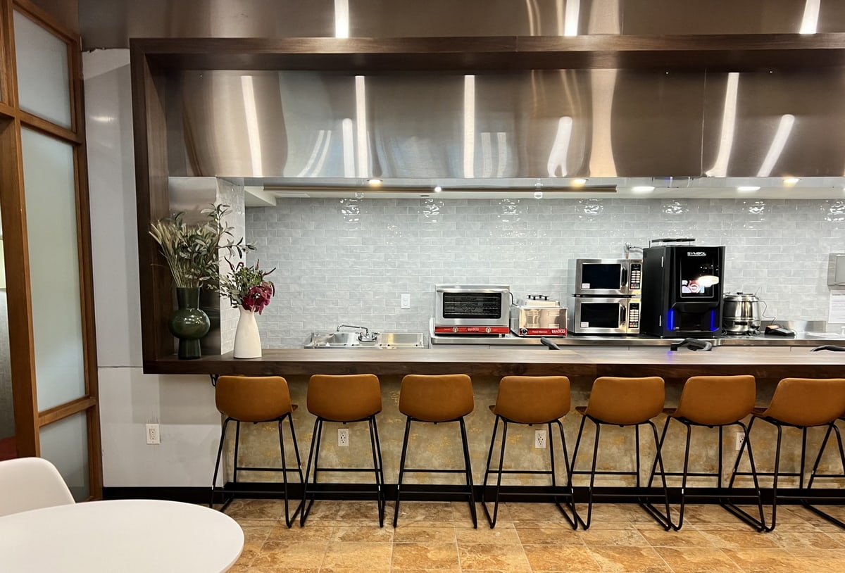 kitchen area with coffee, ovens, and tables.