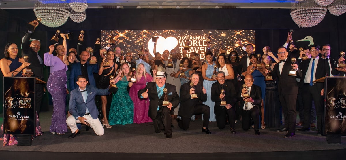 people standing on a stage with their trophies during award ceremony.
