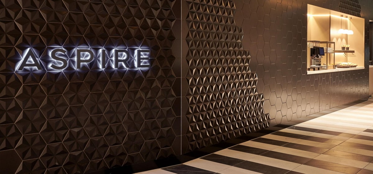 Entrance wall showing Aspire on a dark brown wood surface.