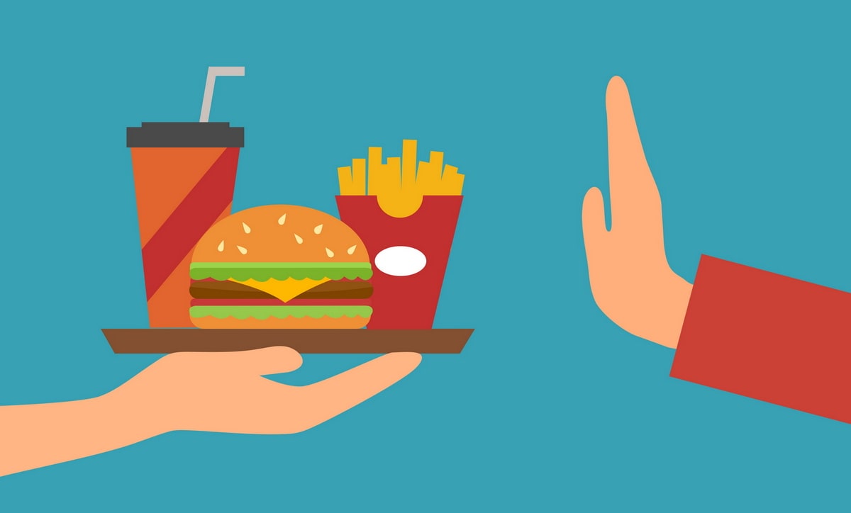 food on a tray with a person hand facing forward to stop.