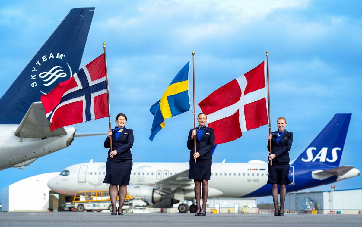 SkyTeam and SAS airplane tails, with employees holding flags.