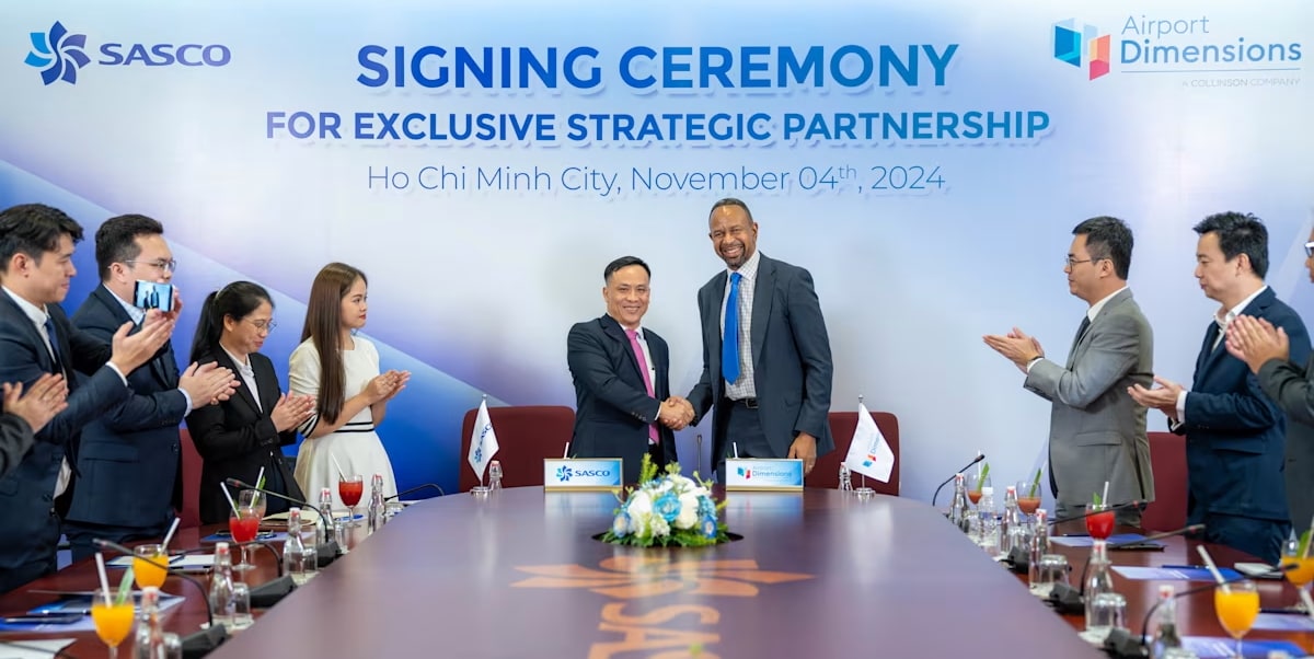 People standing around a desk after signing contract.