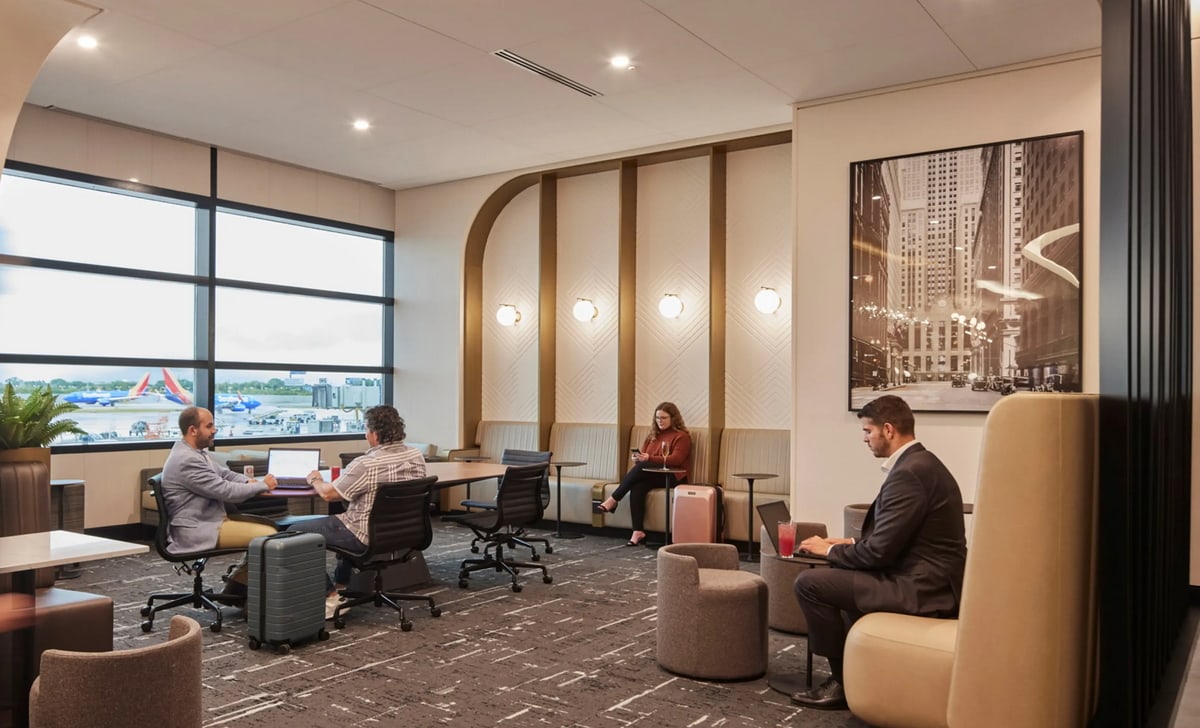 Seating area with people working and windows in the background.