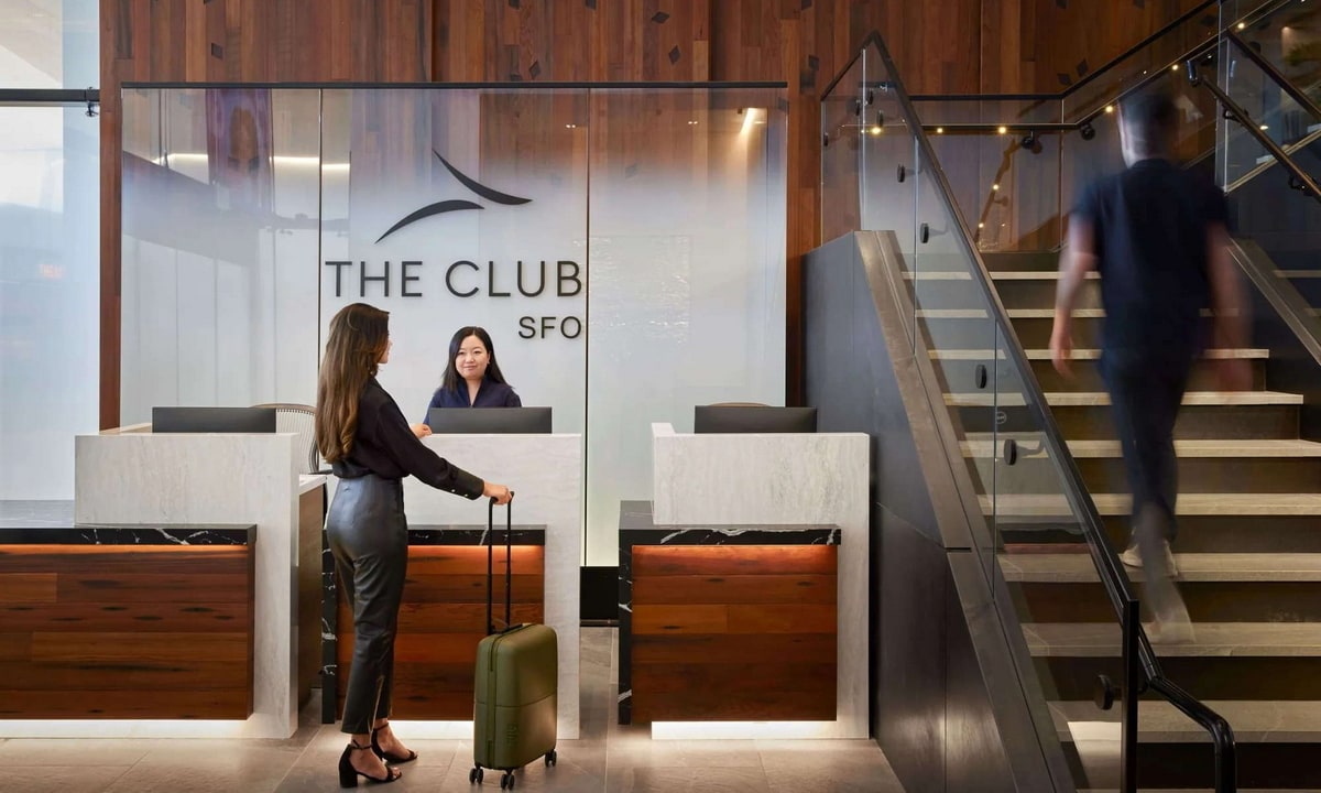 reception desk with a person waiting talking to a lounge employee.