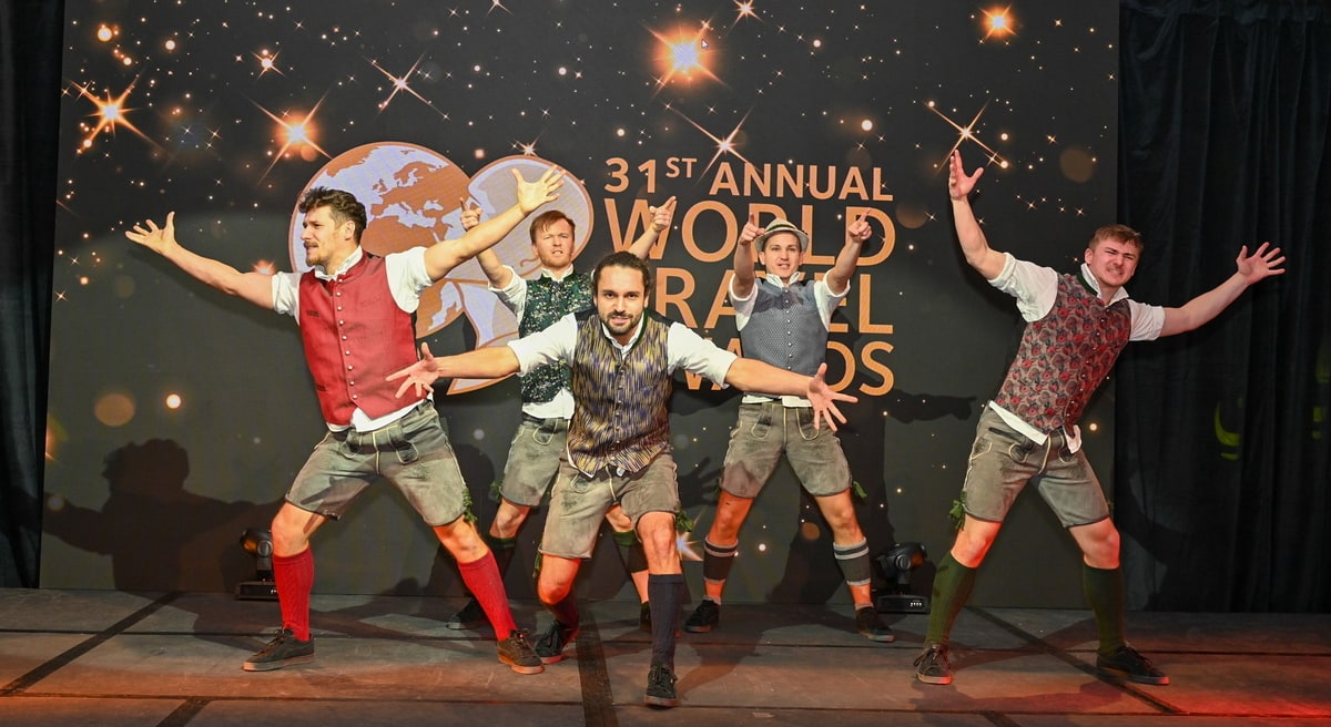 people standing on a stage with their trophies during award ceremony.