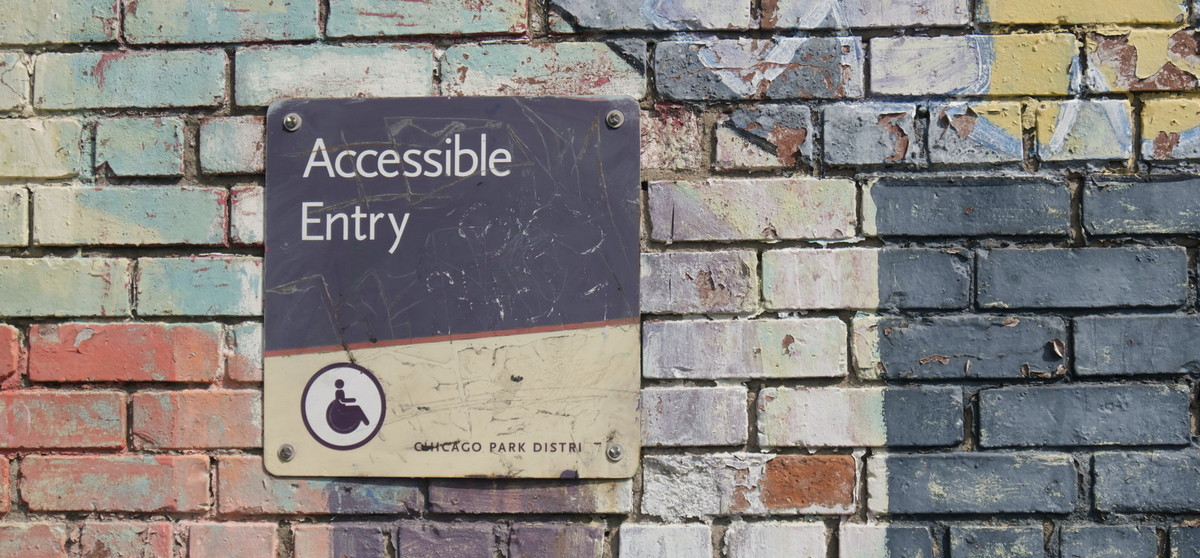 painted brick wall, with sign that reads accessible entry
