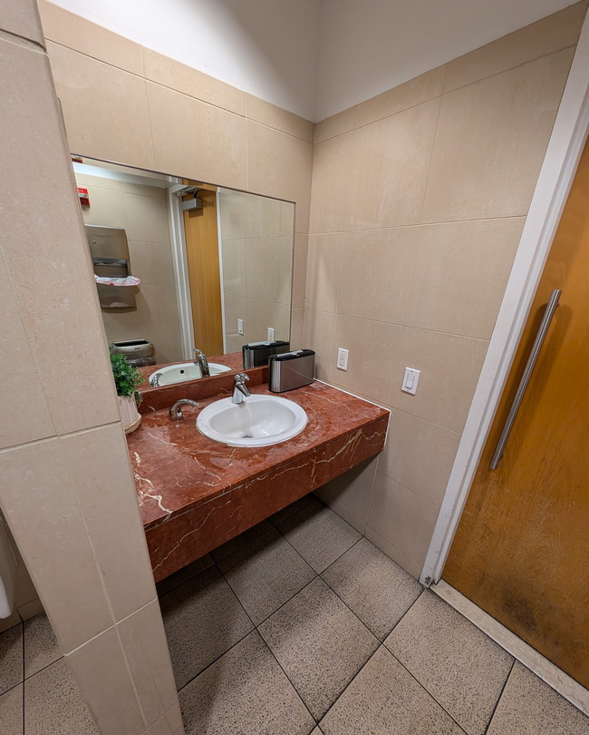 inside the men's restroom sink and mirror