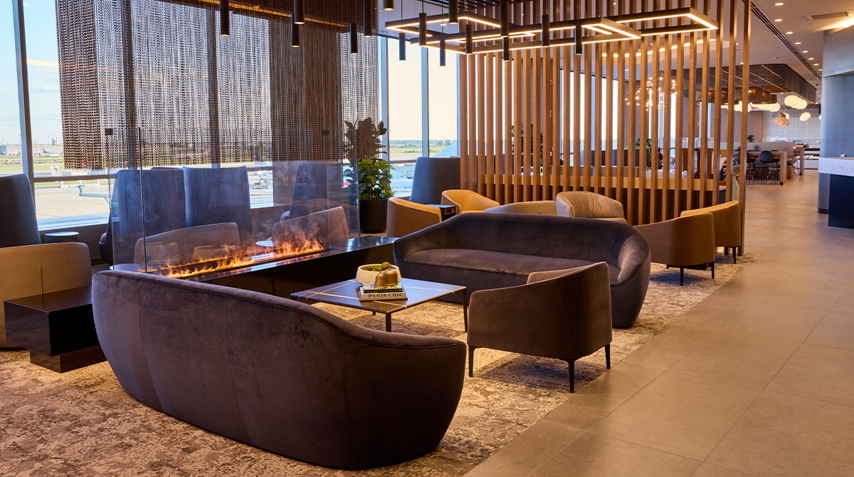 Seating area near fireplace, with windows in the background.