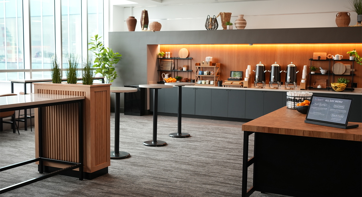 Tables and beverage station. With large windows showing outside the lounge.