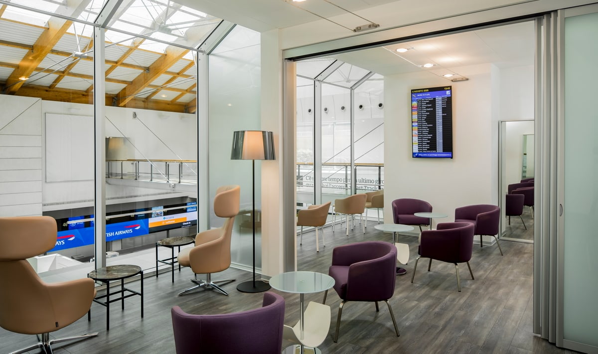 Venice Aspire Lounge seating area with lobby in background. Seating area with tables and view of lobby downstairs.
