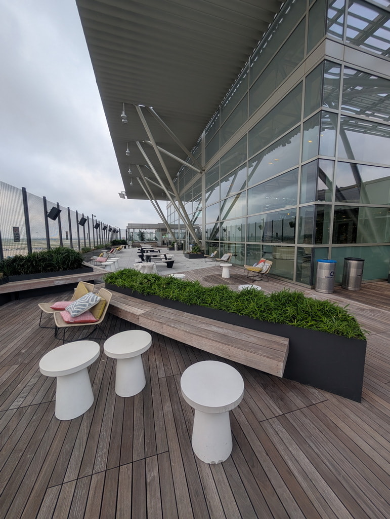 seating, chairs, tables, and trashcans on the deck area.