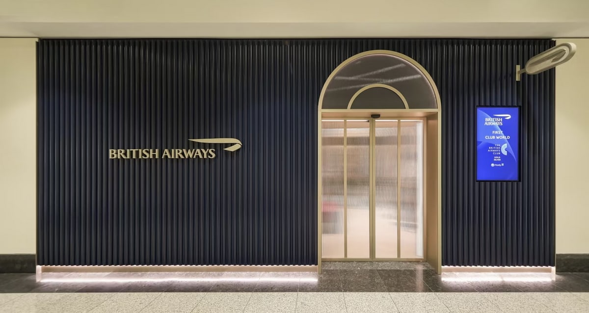entrance to the Dubai British Airways lounge, showing brass and a glass door.