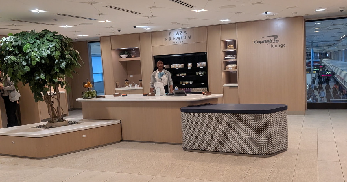Entrance to the Capital One Lounge in Denver with a person standing behind the reception desk.