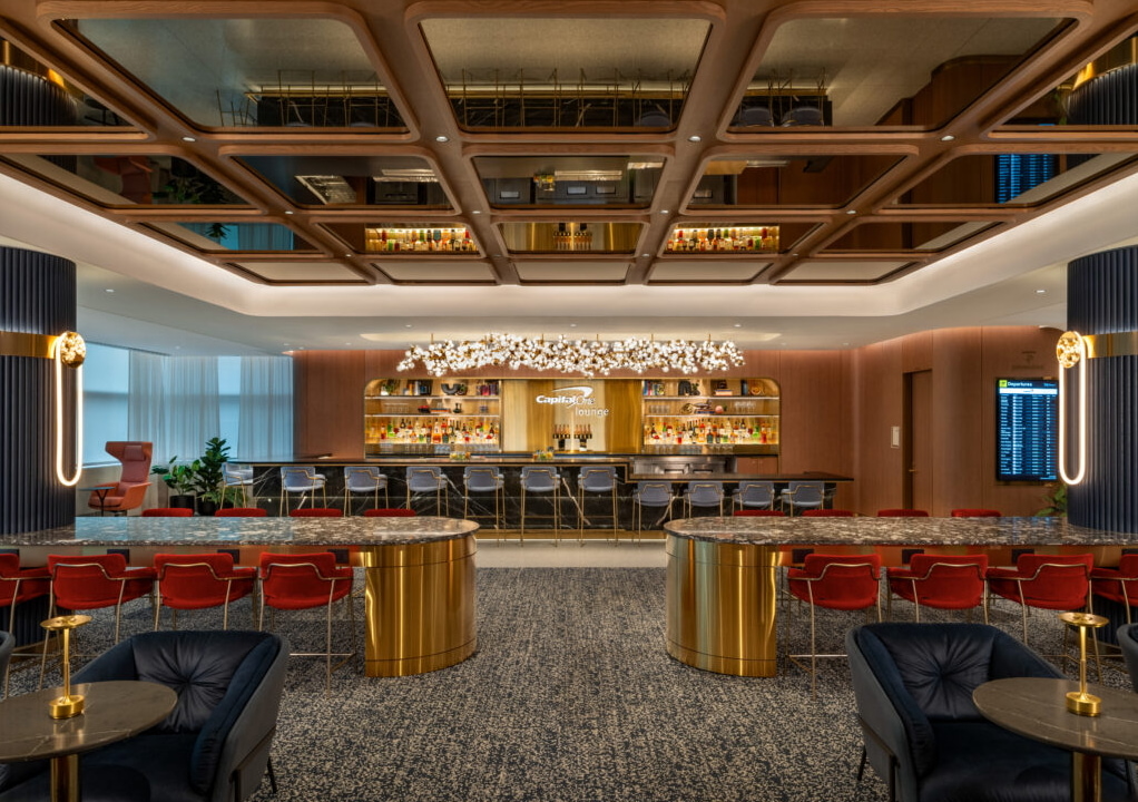 Full-service bar with seating, tables and flight information screen.
