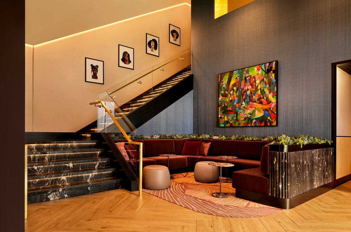 Lobby area with sofas and art, with a large staircase.