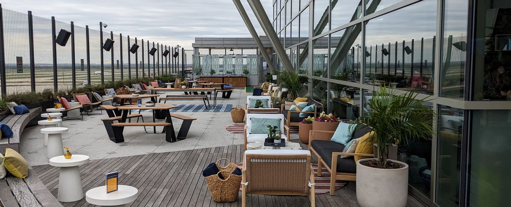 Outdoor deck with seating, tables and views of the runway.