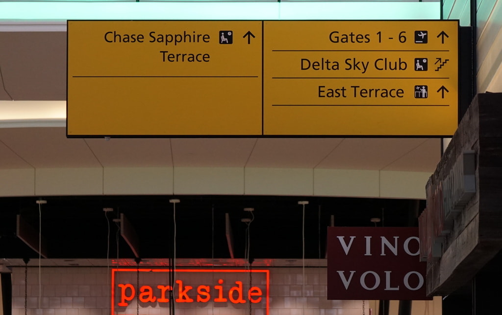 airport signs showing directions to lounge.