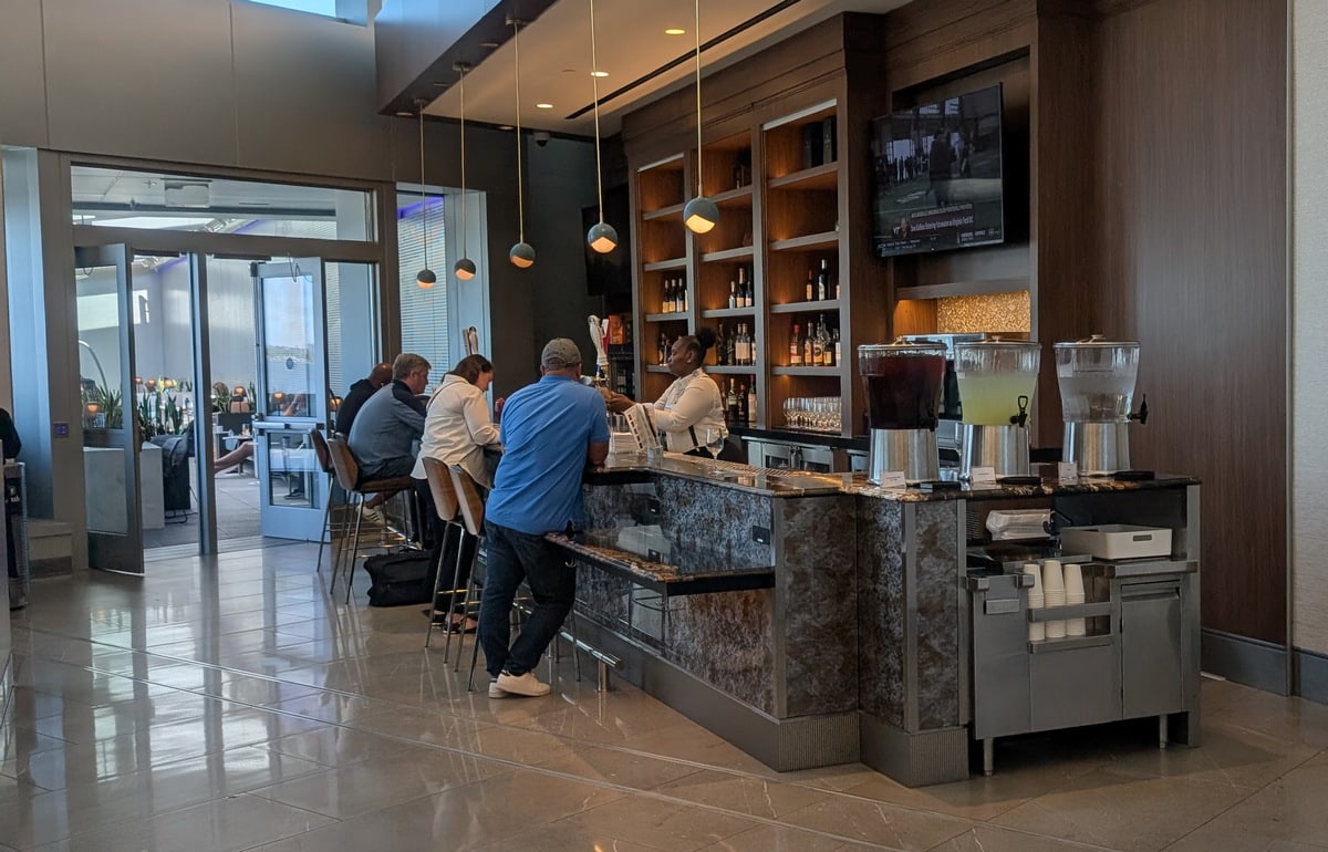 Full bar area with seating and TV in the background.