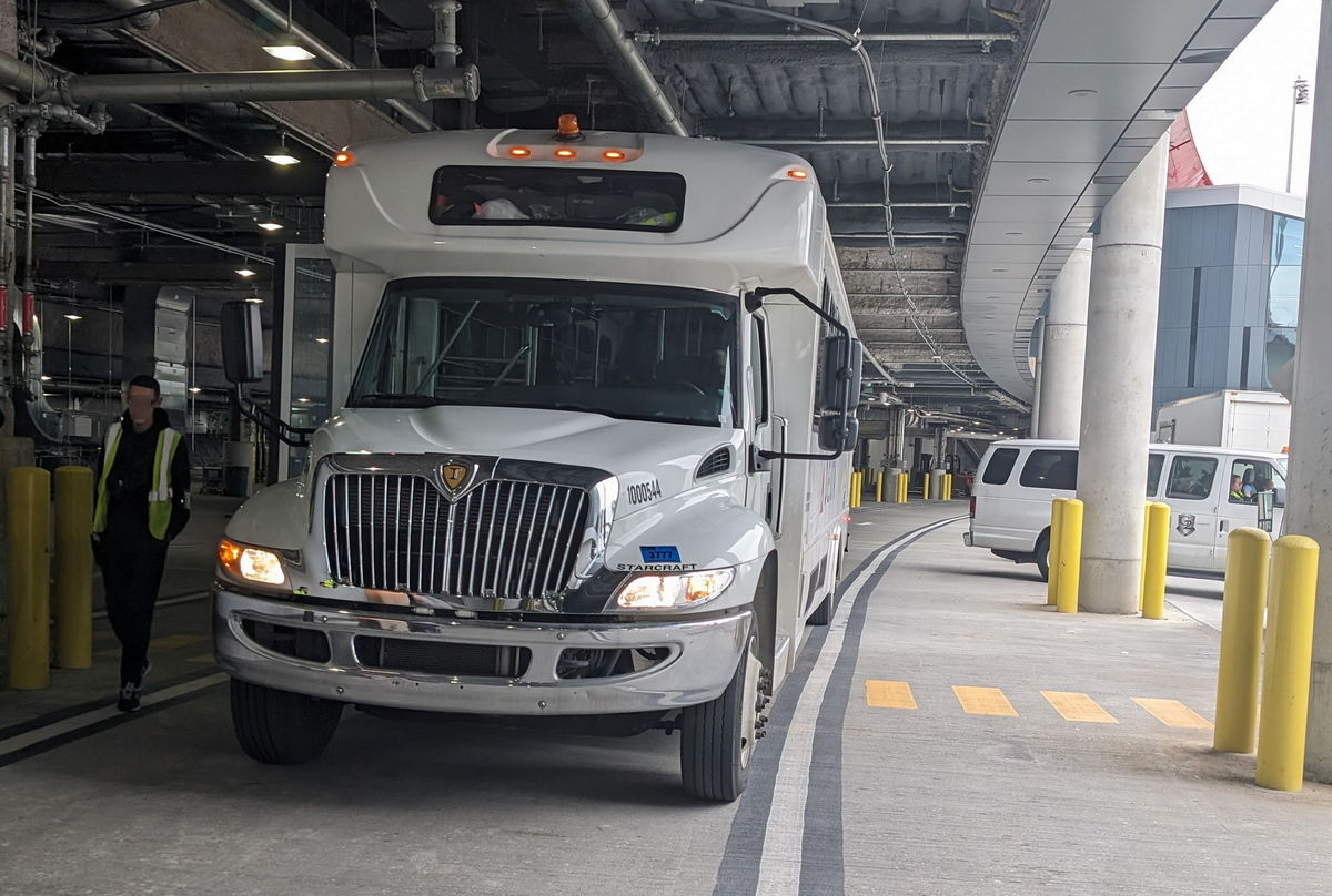 terminal transfer shuttle bus, parked next to elevator.